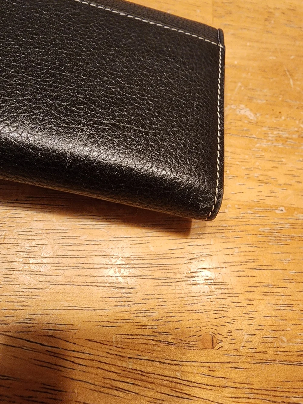 black Christian Dior pebbled leather trifold long wallet featuring gold-tone 